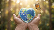 © Muhammad Adnan - Hands holding a heart shaped planet earth with a beautiful monarch butterfly in this photograph