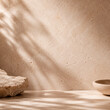 © aitor - Artificial intelligence generated minimal stone platform with warm natural sunlight and soft botanical shadows on textured beige wall. Elegant spa inspired background with organic luxury aesthetic.