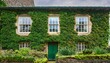 © Tamara - ivy covered stone house facade with green window frames and lush garden front