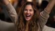 © Emilio - Excited young woman cheering with raised hands and open mouth indoors. Happy emotional female celebrating success, victory or good news with energetic facial expression at home party