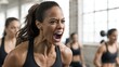© Emilio - Powerful woman yelling during intense gym workout with training group. Athletic female showing strength, determination and emotional energy in modern fitness studio