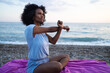 © SISMIZ - Woman stretching arms on beach at sunrise, practicing yoga and mindfulness