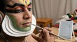 © Sergo - Kathakali artist meticulously receiving classical makeup, transforming the performer into a character for the traditional indian dance drama from kerala, india