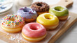 © islamamar - Variety of colorful glazed donuts with sprinkles and toppings on a wooden