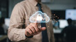© HADI INCREDIBLE - Businessman pointing at a glowing cloud icon with a padlock representing cloud security and data protection in a modern office environment.
