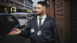 © Krakenimages.com - Man with beard wearing detective badge and id gestures palm up on a narrow city street beside parked cars and metal shutters; investigation confidence.
