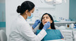 © Someone Cooked Here - indian female dentist examining patient in dental clinic for oral health checkup and preventive dental care concept