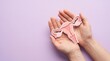 © MstNurjahan - Female reproductive system paper model held in hands, anatomical uterus and ovaries icon on purple background, women health and gynecology concept