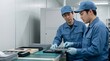 © 望見 柿元 - 工場で電子部品のトレイを確認する若手技術者と指導員のOJT風景