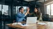 © StockSphere - Happy successful business team of two executive partners employees giving high five supporting celebrating professional success growth financial work achievement sitting at office meeting with laptop.
