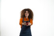 © R Photography - Smiling barista in apron holding takeaway coffee cup and pointing at it, isolated on white studio background.