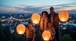 © Sutatik  - Família soltando lanternas ao entardecer com as luzes da cidade ao fundo.