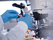 © Westend61 - Scientist holding blood sample tube by microscope in laboratory