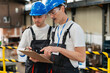 © Westend61 - Factory worker discussing plan on clipboard with supervisor