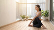 © Ratchanon - Young woman practicing yoga on balcony, morning sunlight, peaceful atmosphere, indoor plant, fitness, relaxation, healthy lifestyle