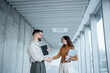 © Migma_Agency - Business partners shaking hands making agreement in office hallway