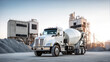 © Shelley - White Concrete Mixer Truck Parked at Industrial Site with Aggregate Piles, Ideal for Construction Projects.