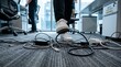 © Pixim Stock - Person walking on office floor with many power cables and extension cords creating tripping hazard risk.