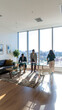 © Freelance - Three people interacting in a modern living room with large windows