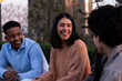 © Ladanifer - Diverse young adults are smiling, laughing, and talking together outdoors in a city setting