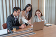 © wichayada - Asian business team collaborating on laptop in modern office meeting