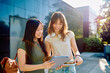 © we.bond.creations - Two young students sharing information on a digital tablet on campus