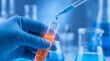 © graphics store - Scientist hand in blue glove holding test tube with orange liquid in laboratory.