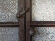 © Zbigniew - Vintage iron grate and latch lock over decorative ceramic wall tile
