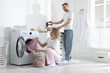 © New Africa - Happy couple doing laundry together at home