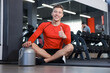 © New Africa - Happy young man with jar of protein powder showing thumbs up in gym