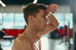 © New Africa - Tired man with sweat on his body in gym