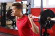 © New Africa - Man sweating while exercising with barbell in gym