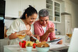 © Marko Geber - Smiling couple cooking dinner together in a modern home kitchen