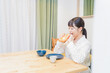 © maroke - 朝食を食べる若い女性