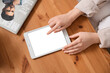 © Pixel-Shot - Young woman using modern tablet computer with blank screen on wooden table, closeup