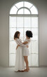 © Wosunan - Happy lesbian couple laughing together and sharing a joyful romantic moment indoors
