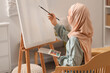 © Pixel-Shot - Little Muslim girl in hijab painting at home
