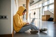 © Евгений Порохин - Young person sits floor, focused on laptop