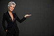 © Shock0991 - Mature Woman in Black Suit Presenting with Copy Space on Dark Background