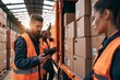 © Khawla - In a logistics retail warehouse, a worker loads cardboard boxes into a delivery van while a female boss uses a tablet computer. Online ordering and purchases