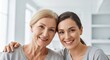 © Iuliia - Senior woman and young woman hugging. Daughter and mother smiling together. Family bonding, generational connection and love. Happy lifestyle portrait of two generations of caucasian women.
