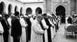 © Afiq Fadzil - Muslim men performing Islamic funeral prayer Janazah in front of a mosque in black and white
