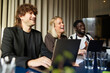 © Johnér - Happy male and female entrepreneurs laughing in business meeting
