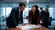 © horizon - Man in a sharp navy suit and a woman in a rich burgundy silk blouse closely examine a printed document together during a business meeting.