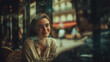 © Anastasiya Ri - Young smiling woman sitting in cozy cafe near window with cinematic reflections and warm evening atmosphere for lifestyle and urban storytelling concepts