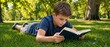 © Vasiliy - Young boy lying on green grass reading a book in a park. Child relaxing and studying outdoors on a sunny summer day. Childhood education and leisure concept