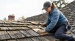 © Irina - Woman repairing old roof shingles with hammer, focused on restoring weathered wooden shingles on rooftop. Home improvement project involves careful installation of shingles for durability.