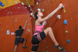 © New Africa - Athletic woman and man climbing wall in gym