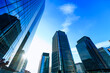 © Takuma Imamura - Abstract low-angle architectural view of glass skyscrapers in Tokyo with clear sky.