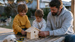 © forenna - Father and two children building wooden birdhouse on back porch, measuring tape and nails visible, dog watching from grass below, modest suburban backyard, golden hour warmth across wooden slats, Fa
